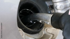 Close-up of a fuel nozzle being inserted into a vehicle's gas tank