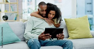 Couple, tablet and laughing with hug on sofa in home at comedy, joke or funny online meme. Interracial, touchscreen and happiness of black man and woman bonding on couch in lounge on social media.