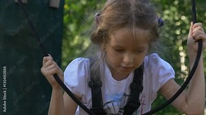 Rope Park Brave Little Girl in Adventure Park Safety Belts Are Fixed on Kid's Chest Girl is Holding a Ropes and Going to Jump Down Sunny Summer Day