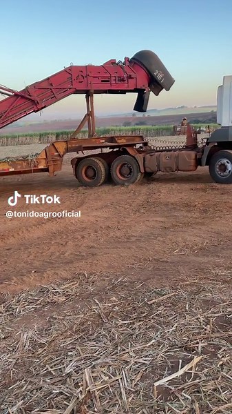 Transporting a Red Combine Harvester in Rural Fields