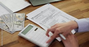 Calculation of amount on 1040 calculator and individual tax form W9 are on table of American citizen. Payment and accounting of taxes