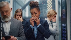 Middle Aged Woman Sneezes in a Crowded Glass Elevator in a Modern Office Building. Businesswoman Covers Her Face, but Other People Are Afraid to Catch the Virus and Microbes in a Lift.