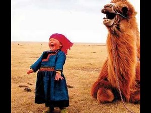A little girl in Mongolia shares a laugh with her camel.