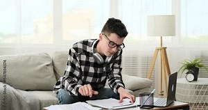 Seated on the sofa, a distressed student vents their frustration by tearing documents and throwing them aside. The moment captures their emotional release and reflects the pressures.