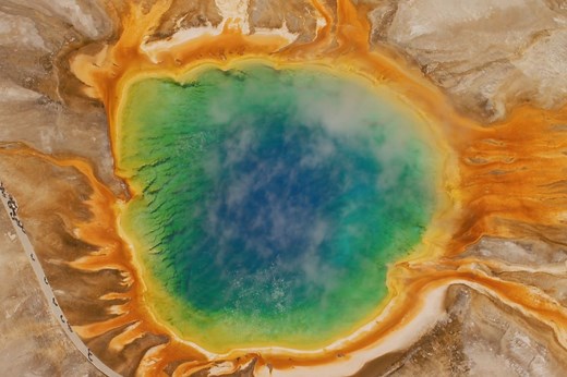 Take a moment to be captivated by steam floating above the vibrant colors of Yellowstone's Grand Prismatic Spring. It's a truly mesmerizing natural wonder! 🤩 | Visit USA Parks