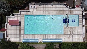 clip-1077269288-drone-flying-over-swimming-pool