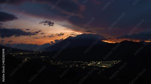 beautiful timelapse of day to night of volcano with eruption and antique town of antigua guatemala from a high vantage point with drone