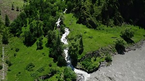 Aerial Snapshot of a Crystal-Clear Stream Merging with a Silt-Laden River in Lush Green Terrain