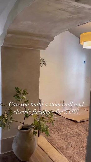 $50 for the stonewall and $100 for the faux fireplace log holder! Read on! 👇🏻 For an oversimplified tutorial 👇🏻 Stonewall: We used sanded mortar to outline the “grout lines” of our stones, built up the “stones” with drywall texture for the 3D effect, layered in colored grout for dimension, then painted linseed oil on the top to achieve color depth. Faux fireplace: Framed up the boxes with 2x4s and drywall, cut backyard cedars for the log holder, used featherlite to achieve a stone/cement tex