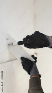Woman hands wearing protective gloves using screwdriver for placing exterior shelf