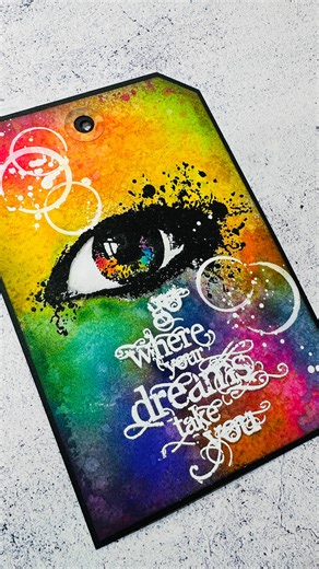 Mark combined vibrant distress ink sprays and our iconic eye stamp to create this striking handmade tag 🌈 Top tip: use masking fluid to protect your white areas when spraying inks.. you’ll never get tired of the big reveal when you remove it! #handmadetags #distressinks #stamping | Visible Image