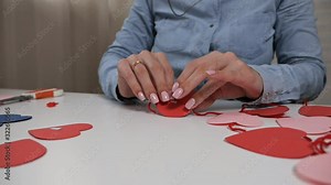 Creativity, girl cut out of red paper with scissors, hearts, flowers, elements for postcards for lovers