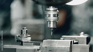 Detailed footage of a precision cnc milling machine in action at an industrial workshop. Witness the intricate process of metal milling for manufacturing