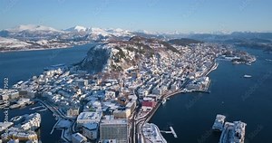 Norway's most beautiful town, Alesund is shown in this breathtaking, winter drone footage that reveals art nouveau buildings, amazing nature, fjords and mountains around it on a nice, sunny day.