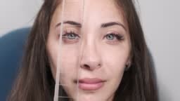 Attentive optometrist examining a beautiful female patient, checking...