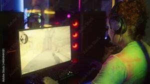 Madrid, Spain - June 13, 2021: Girl plays CS:GO shooter video game in the cyber club. Girl controls the character in a first person shooter computer game. Girl is focusing on winning the shooter game