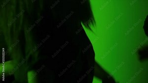 Group of girls dance with each other in slow motion under green light