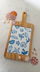 Let’s make a coastal cheese board. I am using a sublimation cheese board from Craft Express and Beacon Adhesives Seashell Glue. First select a design and print it on a sublimation printer. Don’t have a sublimation printer? You can use sublimation pens or sublimation transfer sheets with your cutting machine.Using heat resistant tape add your design to the tile face down. Place your tile sandwiched between siliconized paper. Set your heat press to 356ºF for 300 seconds once pre-heated press it. I