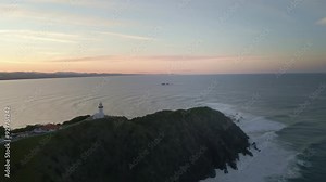 lighthouse of Byron Bay on a cliff with seascape and sunset view in the background in Australia