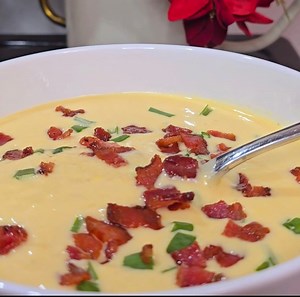 CREAMED CORN CHEDDAR SOUP WITH BACON Ingredients: 5 slices of bacon, chopped 2 cans (398ml) cream of corn 1/4 cup onions, chopped 3 cloves garlic, minced 1 1/2 cups chicken broth 2/3 cup heavy cream Salt and black pepper to taste Chopped chives for garnish (optional) 1/2 cup shredded cheddar cheese Instructions: 1. Cook the Bacon: In a large skillet, cook bacon over medium heat until crispy. Remove and set aside. 2. Blend the 2 cans of cream of corn until smooth. Set aside. 3. Sauté Vegetables: 
