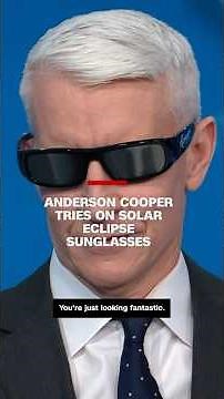 Anderson Cooper tries on solar eclipse sunglasses