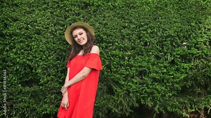 Beautiful happy model standing playful in red dress on nature Stock Video