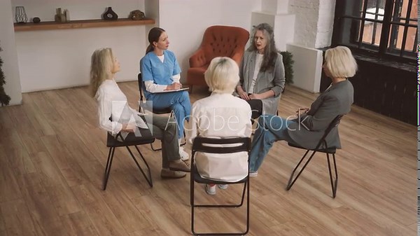 Women group therapy, elderly ladies and health professionals sitting in circle. Discussing club for old women, consultation with psychologist, endocrinologist or gynecologist in modern medical clinic