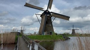 Close-up View to the wooden windmills at sunset in the Netherlands village of Kinderdijk. The beautiful Dutch canals are filled with water. Unesco World Heritage. Holland, Europe from above