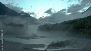 Eerie mist hanging above river in woodland valley in British Colombia, aerial