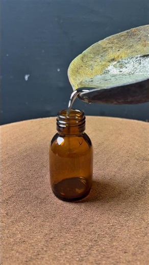 Pouring Molten Silver Into a Glass Bottle