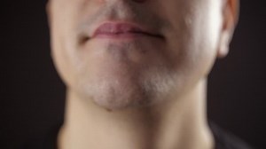 Chocolate smile. Mouth full of chocolate. The guy with candy-stained teeth smiles. Caries and mouth diseases from sweets.