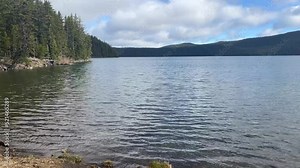 Water ripples gently in late Spring at Paulina Lake with trees and mountains in the background. Taken from the Lakeshore Trail. Deschutes National Forest, near Bend - Oregon.