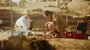 Archaeological Digging Site: Two Great Archeologists Work on Excavation Site, Carefully Cleaning with Brushes and Tools Newly Discovered Ancient Civilization Cultural Artifact, Fossil Remains