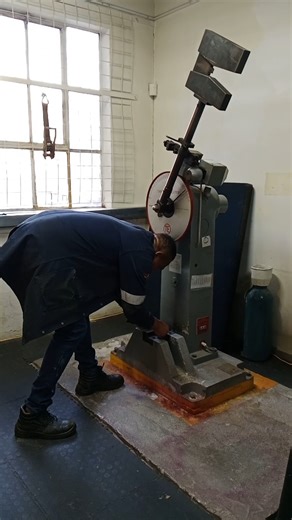 LANDING & SWINGING HEAVY MANUAL HAMMER IN PERFORMING V-NOTCH IMPACT CHARPY TEST AT ROOM TEMPERATURE