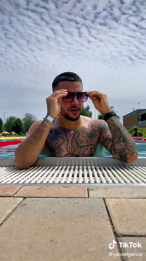 Man Enjoying Poolside Relaxation with Tattoos