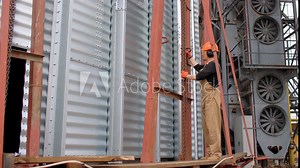 Construction Worker Using Chain Hoist in Silo Building