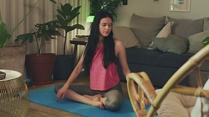 Young woman stretching her body in her living room - Free Stock Video