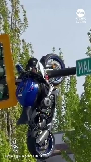 Eyewitness video captured the aftermath of a road accident which left a motorcycle hanging off a traffic light south of Vancouver. The rider is being treated for non-life threatening injuries.
