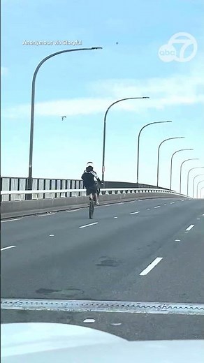 Young person speeding along Australia highway on an e-bike doing wheelies