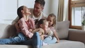 Happy loving family or four laughing hugging cuddling relaxing on...