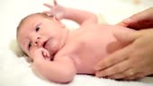 Newborn Baby getting oil massage by his mother