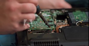 male engineer is focused on repairing electronic circuit board with soldering iron. Man hands soldiers computer circuit board using soldering iron. Slow motion close up cropped view. computer