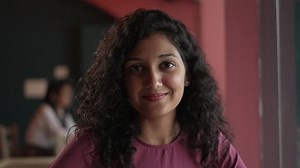Close up of smiling Indian women siting on chair in the coffee shop. happy young Asian business woman pretty face pose looking at the camera. beautiful female and girl face front head shot portrait.