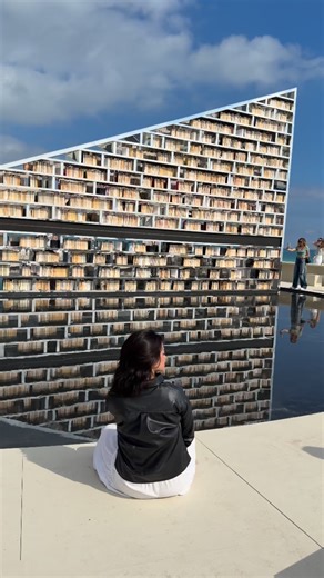 Brenda Chagary on Instagram: "📍Faena Miami Beach, FL. The installation “Library of Us” by Es Devlin is a large circular structure that functions as a rotating library. It’s about 50 feet wide and features more than 2,500 reflective books. The design creates the impression of a library floating above the water, reflecting the sunlight and the movement of the ocean. Is this not the coolest Art Basel installation ever? 🌟 #artbasel #miami #contemporary #artlovers #libraryofus #visualpoetry"