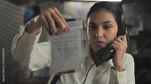 female detective in office picking up crime evidence slow motion,woman police officer speaking at the phone holding plastic bag with bullet inside
