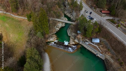 Lechfall, stunning waterfall in Fussen, Bavaria, captured from a high-angle drone shot. The scenic bridge, crystal-clear river, and picturesque landscape make it a perfect travel and photography spot