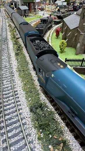 A4 Bittern with two tenders pulls blue and silver coaches down the inner track.