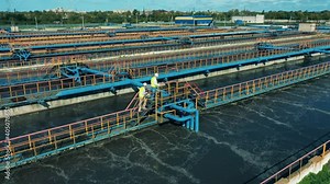Wastewater treatment, sewage treatment concept. Male engineers are walking along the sewage cleaning facilities