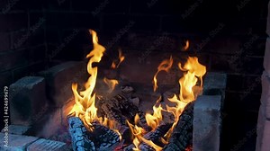 Romantic Fire in fireplace with logs and flames at home. Flames of burning wood logs in log cabin in mountains, close up. Burning woods in campfire at cold winter night. Barbecue. Red flames