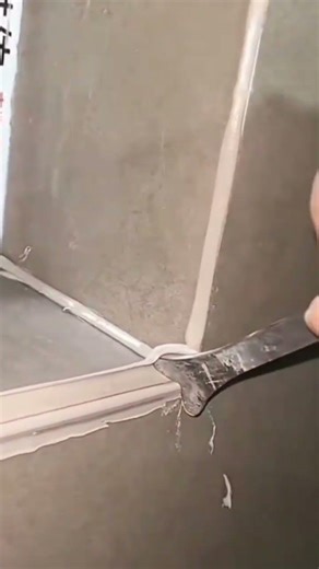Someone smoothes the sealant on a window frame using a tool #construction #popular